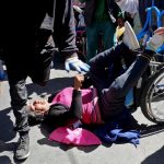 A demonstrator with physical disability falls from a wheelchair during a protest to demand that the government increase the monthly disability subsidy in La Pazwith physical disabilities
